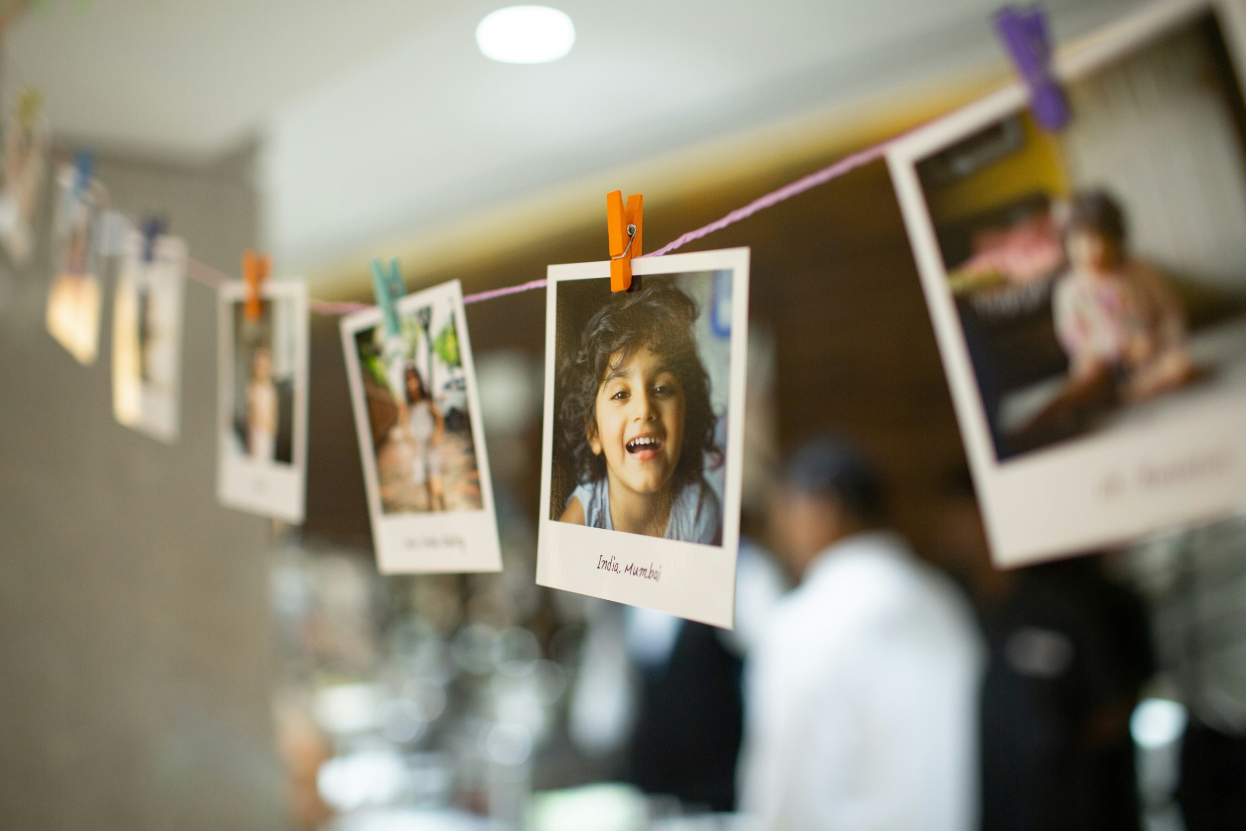 Instant photos of children hanging on a string